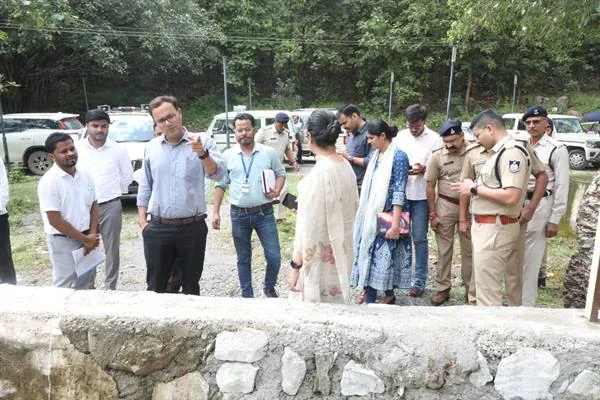 पत्थर की दीवार के पास जलाशय परिसर का निरीक्षण करते अधिकारी और पुलिसकर्मी