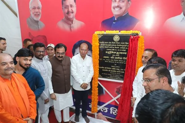 फूलों से सजी शिलापट्टिका के पास खड़े मंत्री, जनप्रतिनिधि, अधिकारी और ग्रामीण